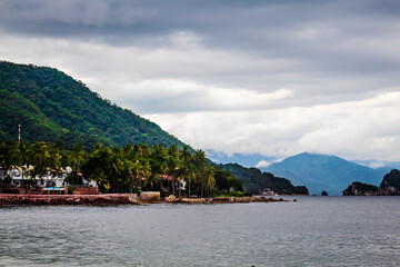 Fototapeta na wymiar beach at cloudy day with green mountains and island in the background, puerto vallarta jalisco 