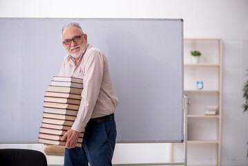 Fototapeta premium Old male teacher sitting in the classroom