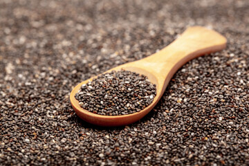 Chia seeds close-up with a wooden spoon. Chia seeds macro. Dry healthy supplement for proper nutrition.