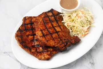 Freshly cooked pork chop served with side dish and gravy