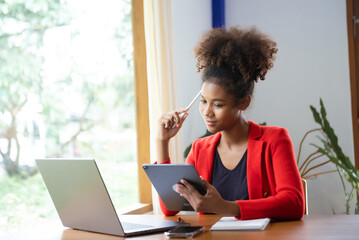 Business woman using tablet and laptop for doing math finance on an office desk, tax, report, accounting, statistics, and analytical research concept