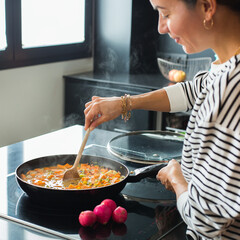 Woman hands adding ingredients in a vegetable stew