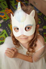 A child in a masquerade carnival mask of a unicorn, made by hand from shiny glitter foamiran and sequins. Masquerade, Carnival, Party, Holiday, Birthday