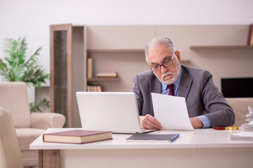 Old male employee working from home during pandemic