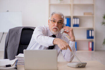 Old male employee working in the office