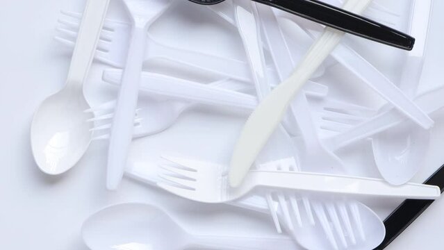 Disposable transparent plastic spoon and fork. Plastic spoon and fork rotating on white background. concept environmental problems.