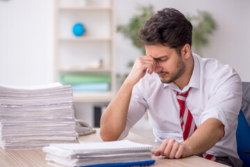 Young male employee and too much work in the office