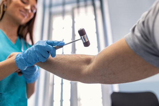 Neurological examination. The neurologist testing reflexes on a male patient using a hammer. Diagnostic, healthcare, medical service