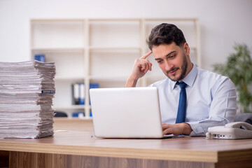 Obraz premium Young male employee and too much work in the office
