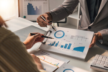 Two business people talk project strategy at office meeting room. Businessman discuss project planning with colleague at modern workplace while having conversation and advice on financial data report