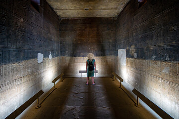 Aswan, Egypt - Person examining old hieroglyphs inside the Temple of Isis 