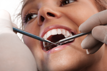 Woman teeth and a dentist mouth mirror on background