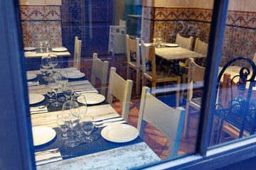 Tables set inside a Small Restaurant with Walls decorated with Colorful Ceramics
