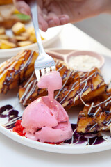 Chocolate waffle with dressing of chocolate sauce and strawberry gelato on the side.