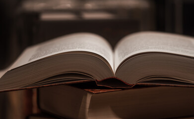 Literature and education concept - opening book or textbook in old library on dark background