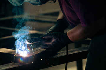 Industry worker welding iron pieces at work