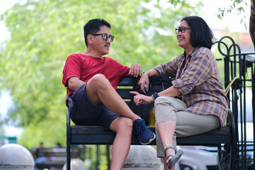 A woman and a man are talking casually in the park