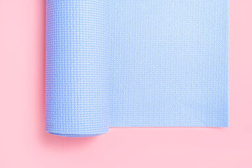 Sports mat for training on a pink background close-up.