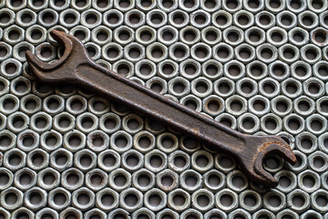 Rust wrench on the background of iron nuts.