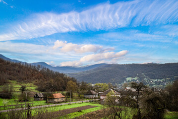 Mountain Village on a Sunny Summer day.Amazing view on a small village on the Mountains .Green valley with fields and villages among mountains.