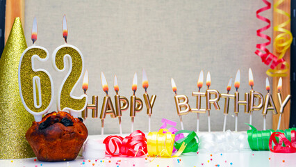 Happy birthday background with golden candles and decorations with candles burning number  62. Colorful festive card happy birthday with a number. Anniversary copy space