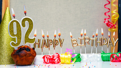Happy birthday background with golden candles and decorations with candles burning number  92. Colorful festive card happy birthday with a number. Anniversary copy space