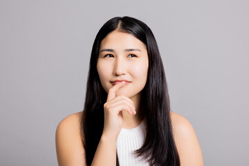 Fototapeta premium Thoughtful asian beautiful woman with long black hair thning natural mae up welness skincare.