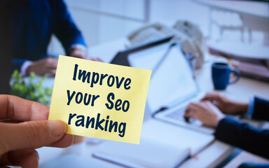 Male hand holding sticky note written Improve your Seo ranking.