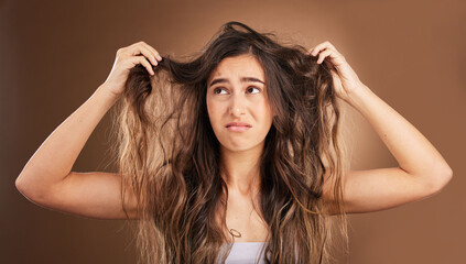 Problem, hair loss and sad woman in studio for beauty, messy and damage against brown background. Haircare, fail and unhappy girl frustrated with weak, split ends or alopecia while posing isolated