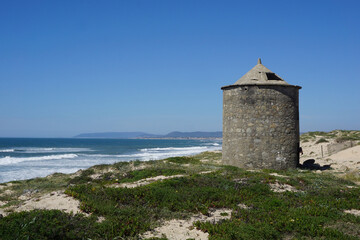 Fototapeta na wymiar Landscape with traditional windmill on the atlantic coast of Portugal