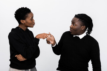 African amercan couple standing over white background in studio isolated arguing blaming each other...