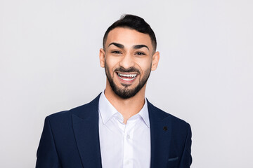 Portrait of happy delighted turkish man in studio isolated over grey background looking at camera smiling with white teeth buisneesman young successful guy.