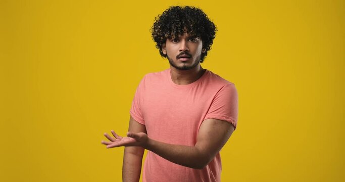 Confused Shocked Young indian man pointing with index finger to the side