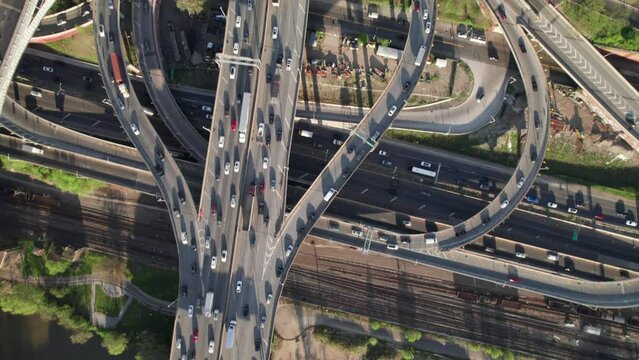 Overhead aerial of crazy traffic interchange with bridges, ramps, rush hour congestion.
