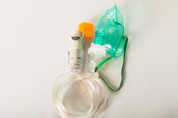 Bronchitis, asthmatic health equipment. A respiratory mask and inhaler are on a light background.