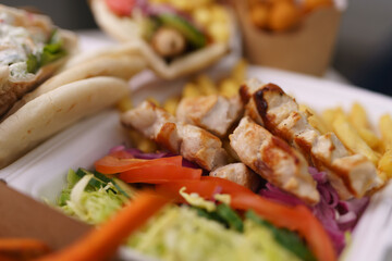 Grilled souvlaki meat served in a Greek fast food restaurant for lunch. Traditional Mediterranean meal in a take away container