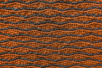 Orange grey crocheted wave pattern. Knitted texture.