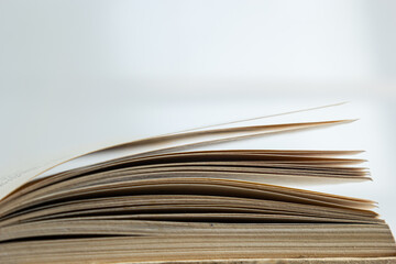 Open old book with text on white background. The concept of reading literature, education and book publishing. Free space for text