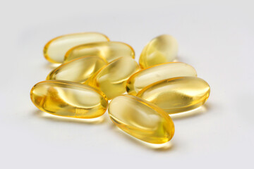 Fish oil capsules omega 3 on light background. Transparent yellow capsules of fish oil