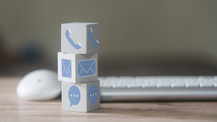 Customer support concept. Stack wood block with icons of contact methods, phone, email, address and...