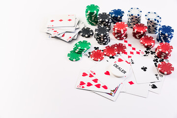 Playing cards and poker chips on white background