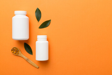 supplement pills with medicine bottle health care and medical top view. Vitamin tablets. Top view mockup bottle for pills and vitamins with green leaves, natural organic bio supplement, copy space