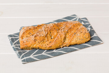 freshly baked bread with napkin on rustic table top view. Healthy white bread loaf isolated