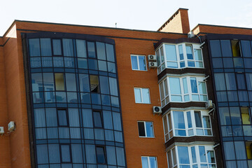 Architectural details of modern high apartment building facade with many windows and balconies
