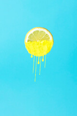 Painted lemon on blue background. Minimal concept.