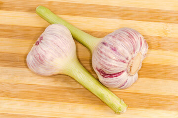 Heads of the young purple garlic on a cutting board