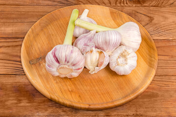 Young garlic and garlic last year's harvest on wooden dish