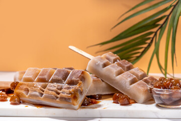 Tapioka latte popsicles. Frozen tapioca boba balls coffee frappe, ice cream lollypops made with asian cold tapioca coffee, with coconut cream and caramel sauce