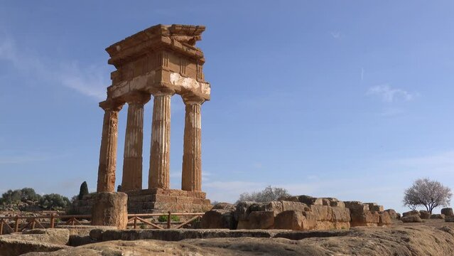 Panning with landscape of ancient Tempio dei Dioscuri or Tempio di Castore e Polluce temple in Valley of the Temples in Agrigento, Italy
