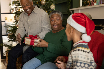 Multigenerational family together at Christmas time giving gifts